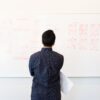 man standing infront of white board